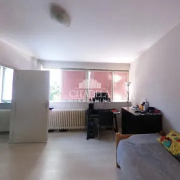 Small bedroom with a bed, a desk, and a window. - image 4