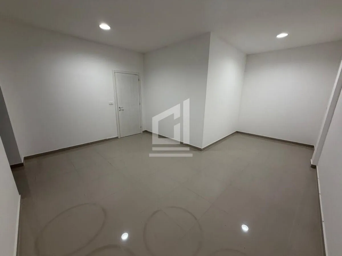 Empty unfurnished room with white walls and tiled flooring.