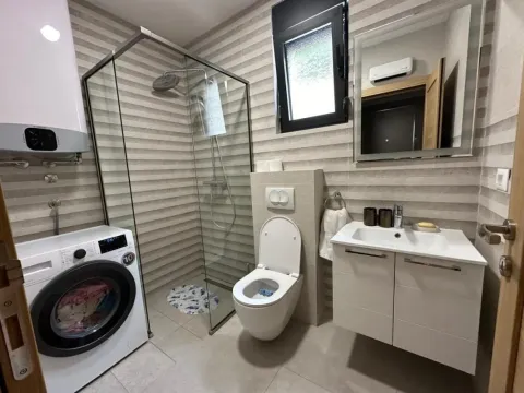 Kupatilo opremljeno tuš kabinom, umivaonikom i veš mašinom. - image 6