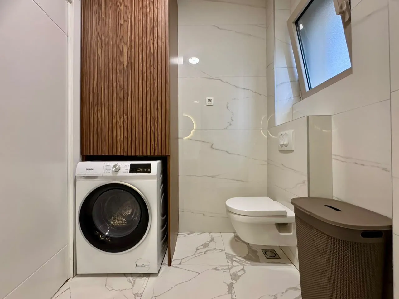 Modernly equipped bathroom with a washing machine and built-in units.