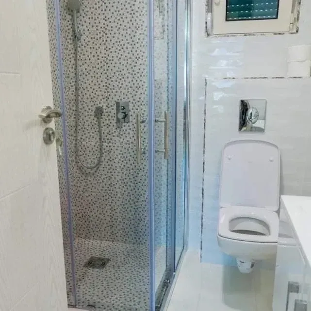 A modern bathroom equipped with a shower cabin and toilet.