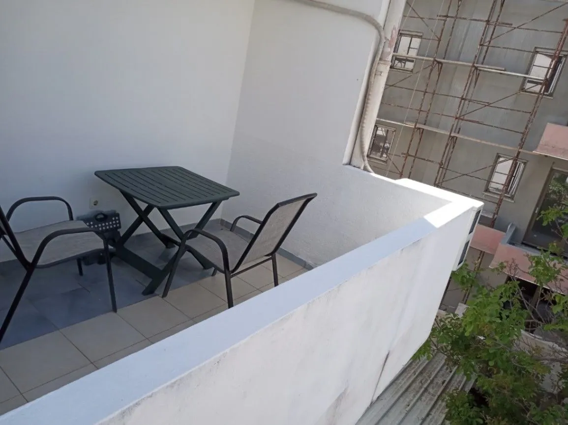 Small balcony with a table and two chairs.