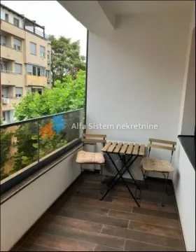Natkriveni balkon sa staklenom ogradom i garniturom za sedenje. - image 11