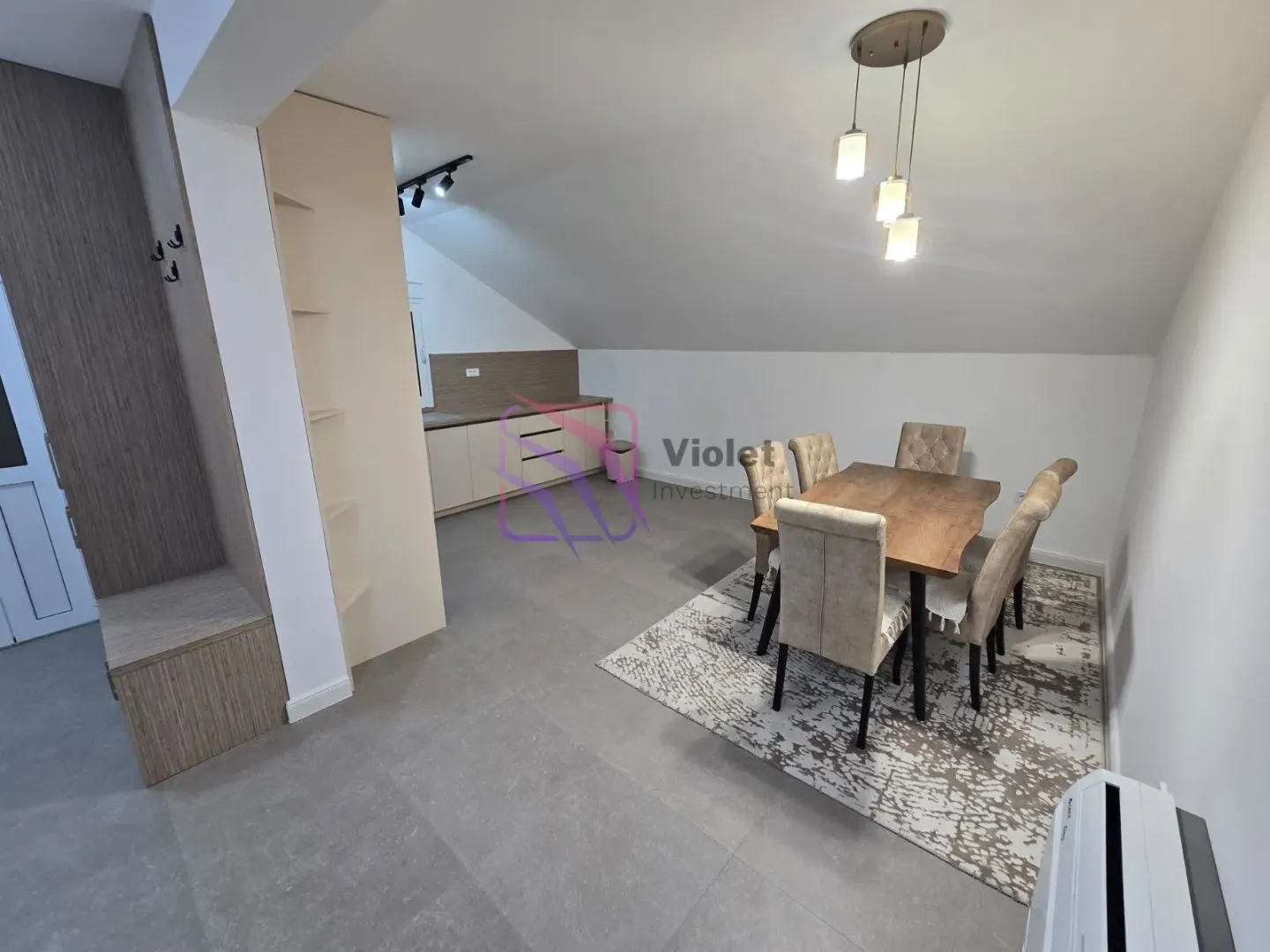 Dining area with a wooden table and chairs adjacent to the kitchen.