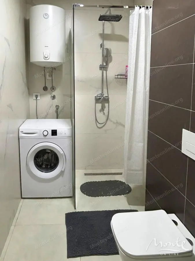Kupatilo sa tuš kabinom, WC šoljom, bojlerom i veš mašinom.