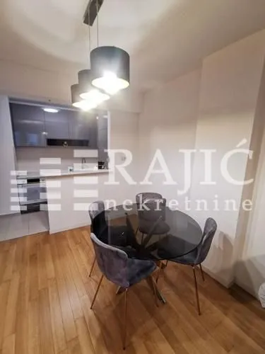 Dining area with a table and chairs and a view of the kitchen.