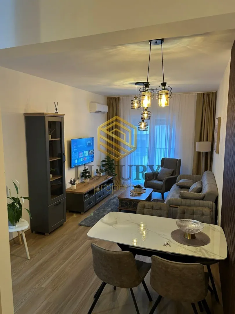 Dnevni boravak sa trpezarijom i modernim nameštajem.