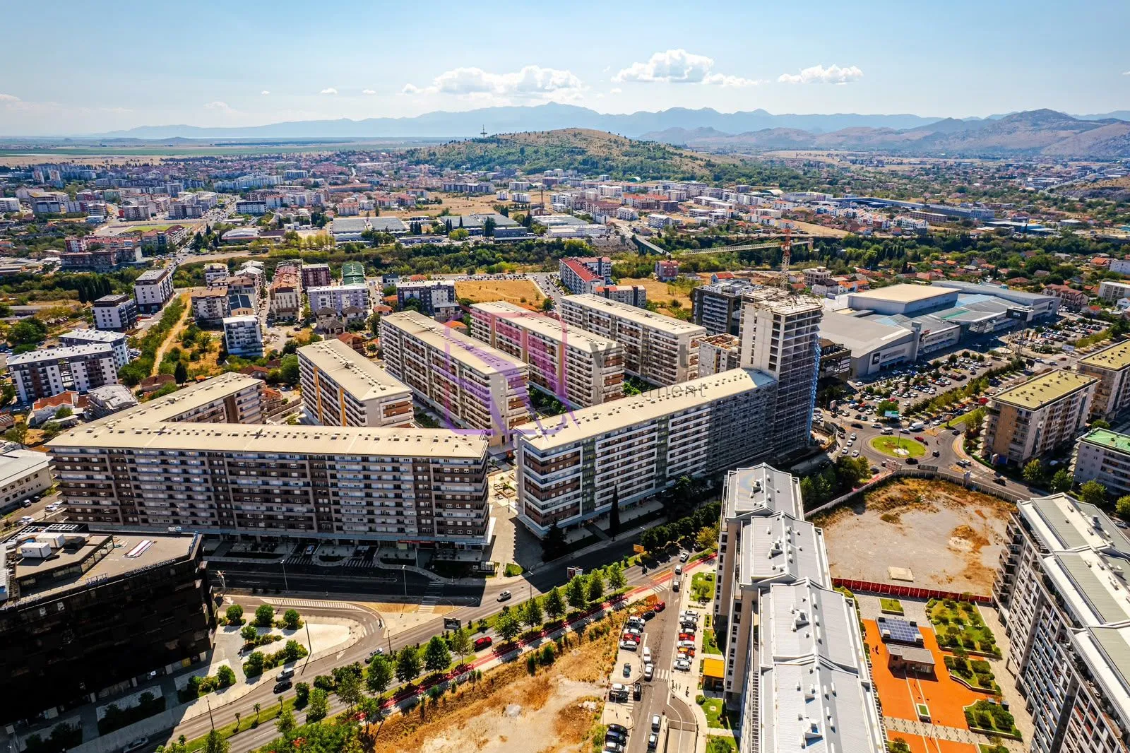 Pogled iz vazduha na gradsko naselje sa zgradama i okolinom.