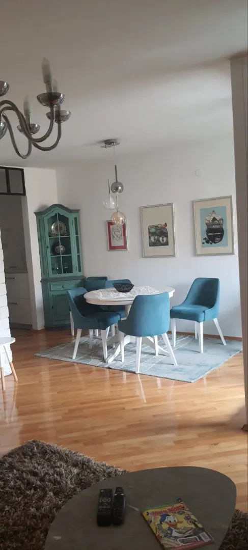 Dining area with blue chairs within a living room.
