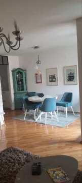 Dining area with blue chairs within a living room. - image 3