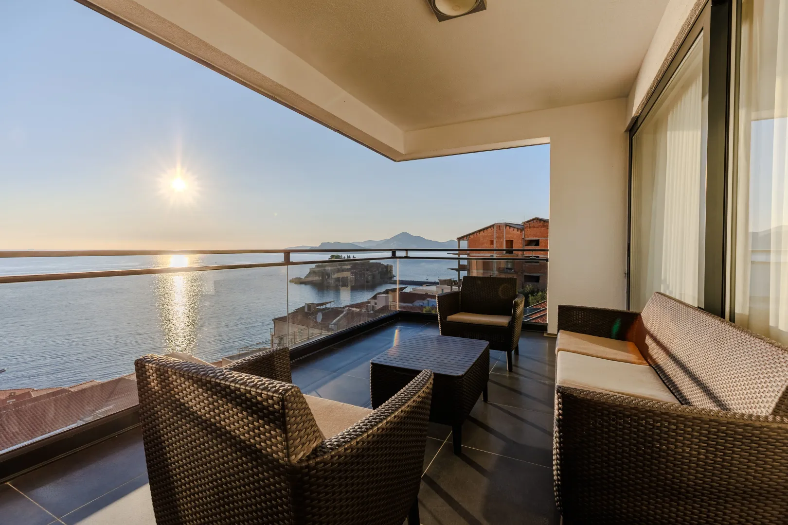 Furnished balcony with seating set and sea view.