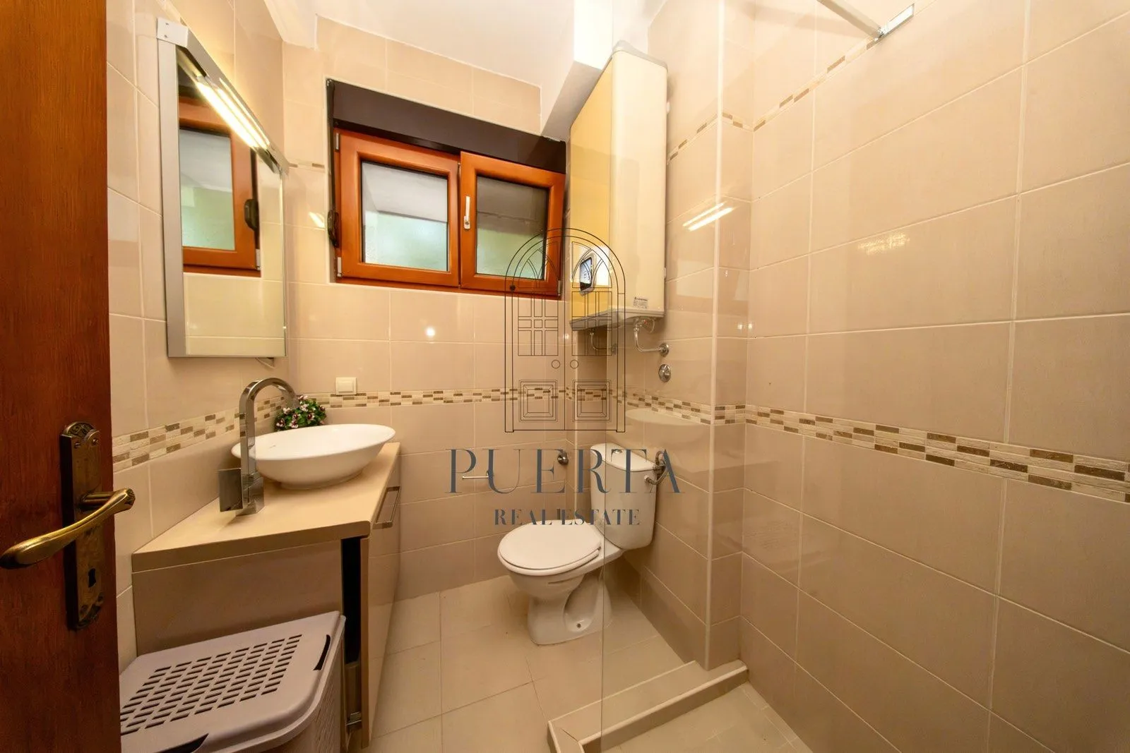 Small bathroom with a washbasin, toilet, and shower cabin.