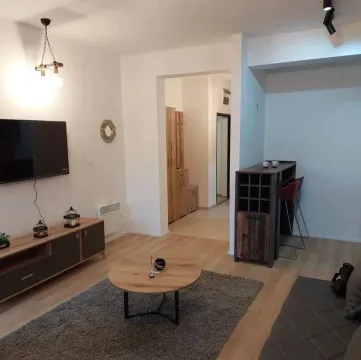 Dnevni boravak sa garniturom, TV-om, stočićem i šankom sa barskim stolicama. - image 6