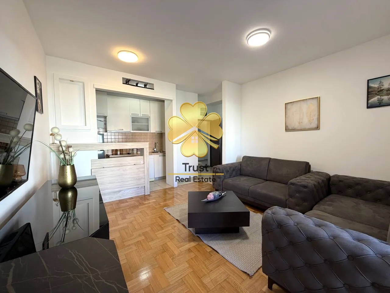 Spacious living room with a sofa set and a view towards the kitchen.