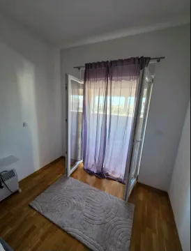 Soba sa drvenim podom, tepisihom i balkonskim vratima. - image 4