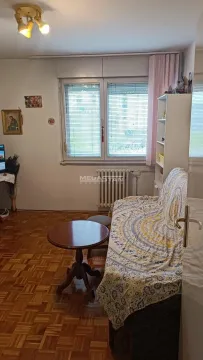Manja dnevna soba sa garniturom za sedenje i parketom na podu. - image 9