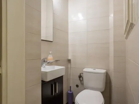 Smaller tiled bathroom with a sink and a toilet. - image 5