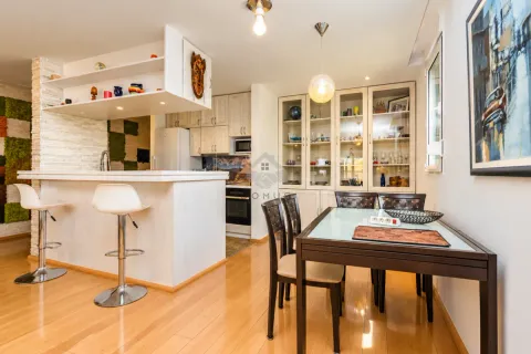 Kitchen with a breakfast bar and dining table. - image 12