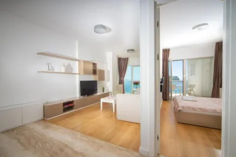 View of the living room with a sea view and an open doorway leading to the bedroom. - image 10