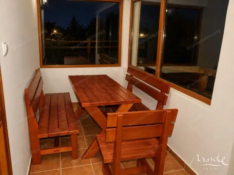 Enclosed terrace with a wooden table and benches. - image 17