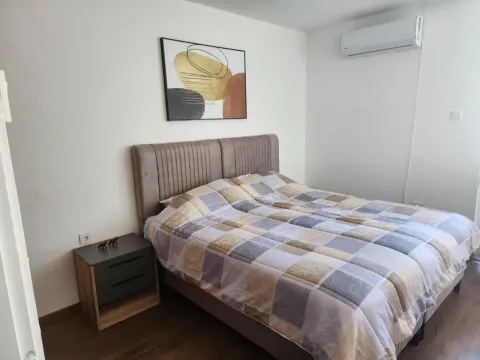 Spavaća soba sa bračnim krevetom, noćnim stočićem i klima uređajem. - image 8