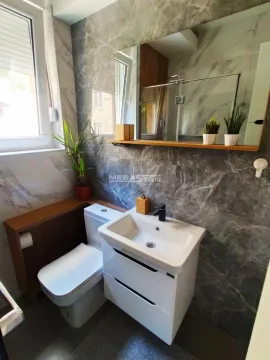 Modernly equipped bathroom with a washbasin, toilet, and mirror. - image 19
