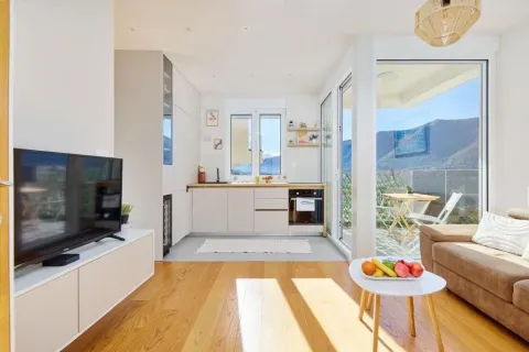 Living room with kitchen, dining area, and access to a terrace with mountain views. - image 4