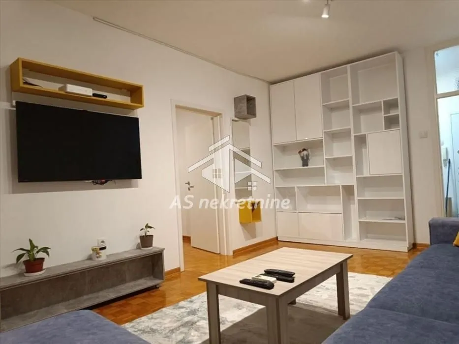 Living room with a sofa set, television, and built-in wardrobe.