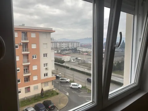 Pogled kroz prozor na okolne zgrade i ulicu. - image 2