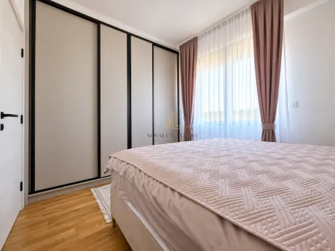 A bedroom with a large double bed, built-in wardrobe, and a window with curtains. - image 11