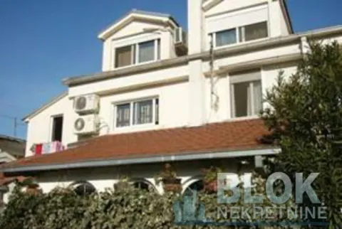 Exterior view of a multi-story house with a white facade and a tiled roof. - image 3