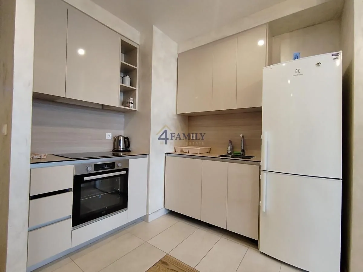 Modern kitchen with white cabinetry and built-in appliances.