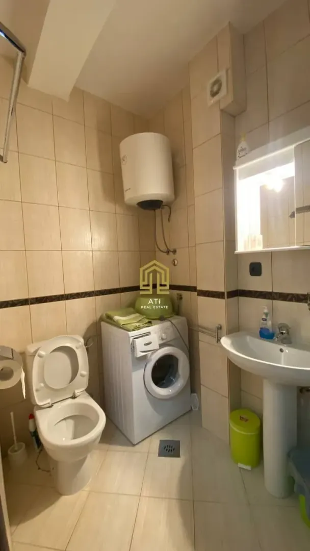 Pogled na kupatilo sa sanitarijama, umivaonikom i veš mašinom.