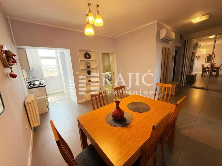 Dining area with a wooden table and chairs, connected to the kitchen.