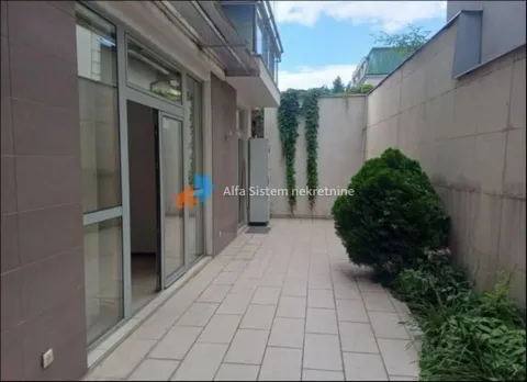 Paved courtyard in front of the building entrance with landscaped green areas. - image 14
