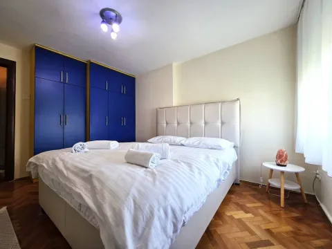 Uređena spavaća soba sa bračnim krevetom i plavim garderoberom. - image 9