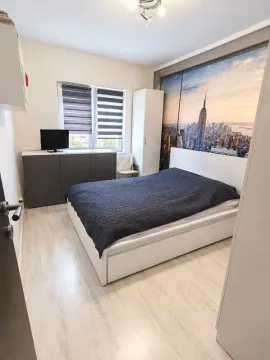 Nameštena spavaća soba sa bračnim krevetom i tapetom sa motivom New Yorka. - image 9