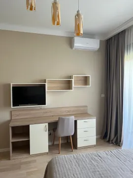 Furnished bedroom with a desk and TV. - image 9