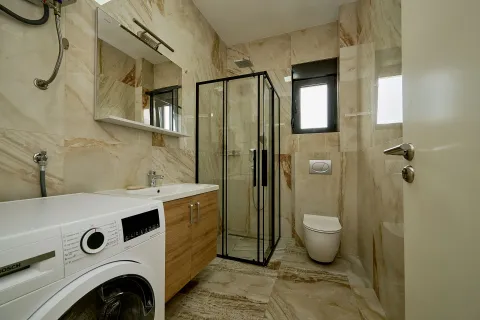 Moderno opremljeno kupatilo sa tuš kabinom, umivaonikom i veš mašinom. - image 13