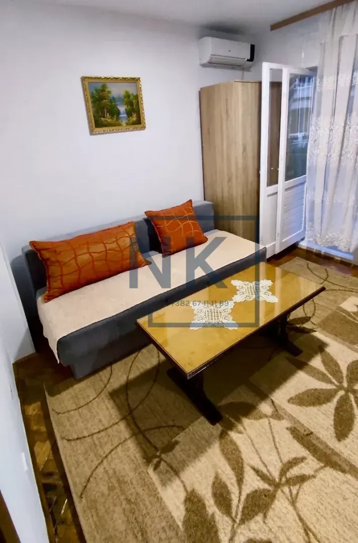 Living room with a sofa, coffee table, wardrobe, and access to the terrace.