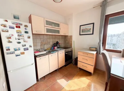 Small kitchen with light-colored cabinets and a refrigerator. - image 5