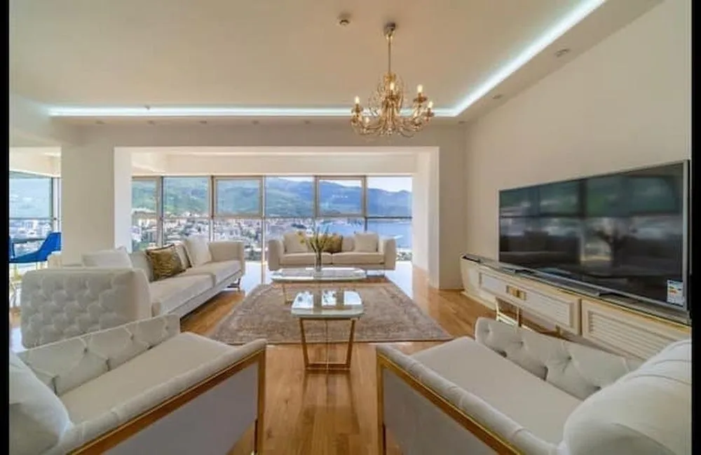 Spacious living room with a sofa set, large TV, and sea view.