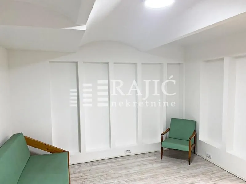 Empty bright room with a green armchair and sofa.