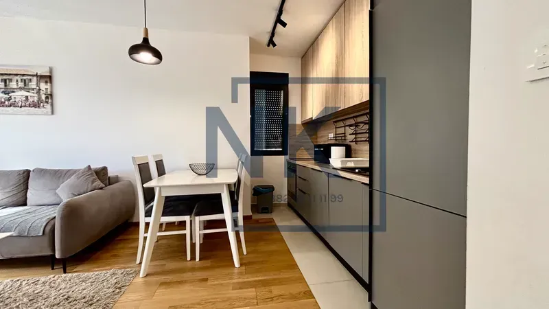 Living room with dining area and kitchen in an open space.