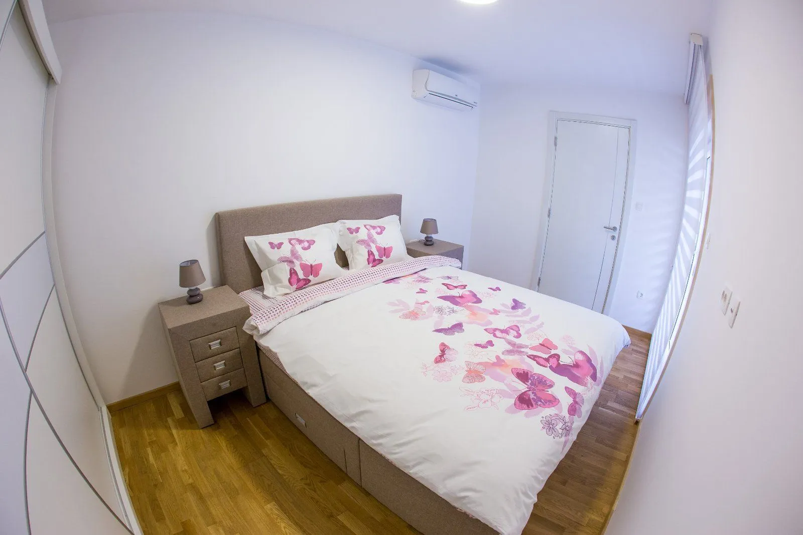 Bedroom with a double bed, nightstands and air conditioning.