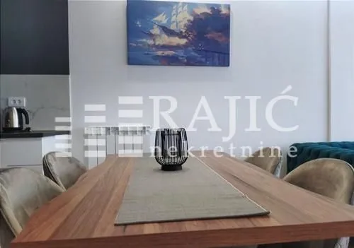 Dining area with a wooden table and chairs in a modern apartment.