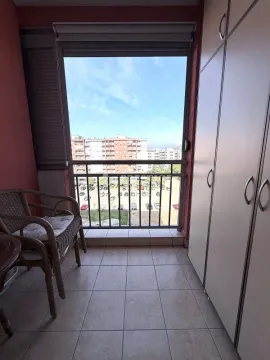 Small enclosed balcony with a built-in closet and city view. - image 16