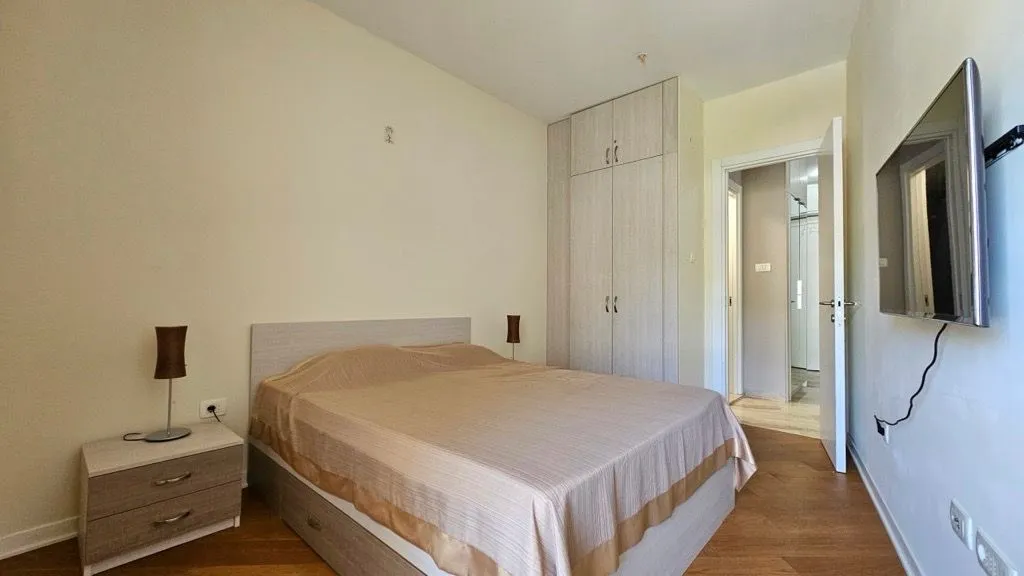 Bedroom with a double bed, wardrobe, and wall-mounted TV.