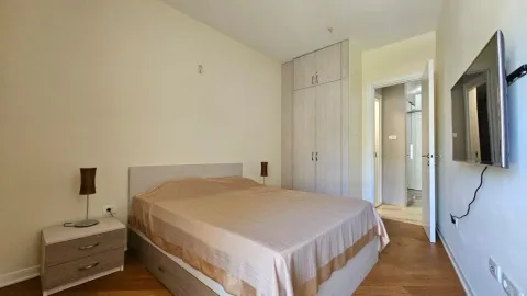 Bedroom with a double bed, wardrobe, and wall-mounted TV. - image 5