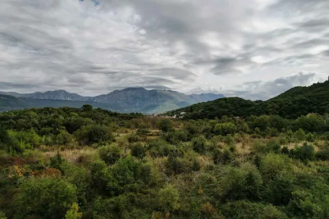 Pogled na zelena brda i planinske vrhove pod oblačnim nebom. - image 9